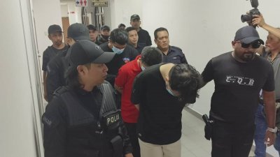 6名男子涉嫌非法拘禁及谋杀一名24岁华裔青年，周三被大批特警押往新山推事庭面控。