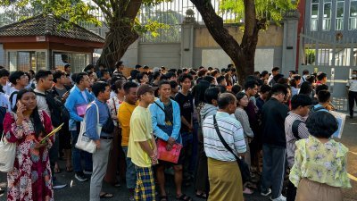 缅甸仰光市的泰国大使馆外，周五有大批年轻人等候入内申请签证，他们不想被军政府强征服役对抗反抗军。（图取自法新社）