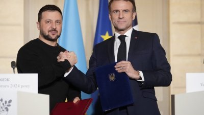 乌克兰总统泽连斯基（左）当地时间周五与法国总统马克龙会晤，并在巴黎爱丽舍宫签署双边安全协议。（图取自法新社）
