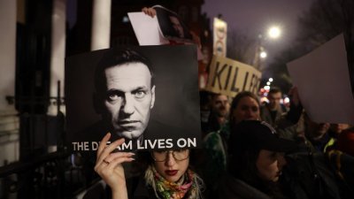 俄罗斯驻伦敦使馆外有100多名抗议群众聚集，高举纳瓦尔尼照片及标语牌称普京是战犯。（图取自法新社）