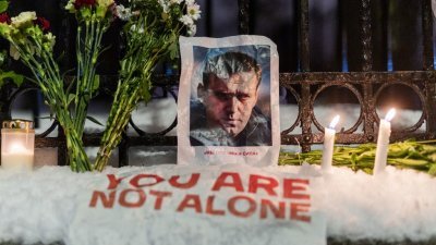 在纳瓦尔尼传出死讯之后，周五晚间，欧洲各地民众纷纷集会示威与悼念。图为挪威奥斯陆的俄罗斯大使馆前，人们举行集会并摆放鲜花和纳瓦尔尼的照片。（图取自法新社）