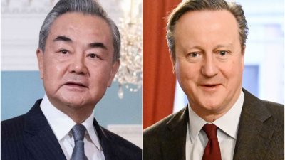 英国外交部长卡梅伦（右）与中国外交部长王毅，周五在德国慕尼黑安全会议期间会晤。（图取自法新社）