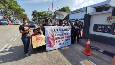 贝拉逾20名亲友聚集在峇株巴辖法庭外高举大字报，呼吁当局尽速审理将案件转至高庭裁决。