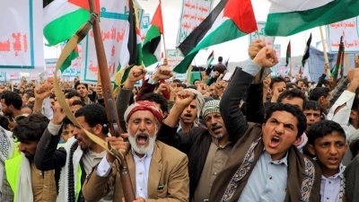 也门人上周五在“青年运动”控制的首都萨那游行时挥舞著武器，高喊口号并挥舞巴勒斯坦旗，以支持巴勒斯坦人。（图取自法新社）