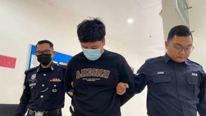 27岁被告（中）被警员押离麻坡地庭。（图取自每日新闻）