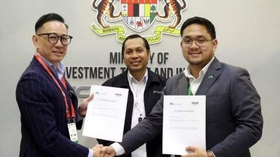 任明辉（左）与穆札基尔（右）在马来西亚国家航空业协调办事处处长山苏卡玛的见证下，签署合作协议。