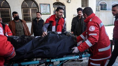 以色列对加沙地带南部的拉法难民营发动空袭，医护人员当地时间周六（24）将一具尸体运送至拉法的纳贾尔医院。（图取自法新社）
