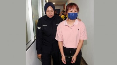 女被告被庭警押往法庭面控。