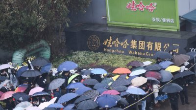 尽管细雨绵绵，来自四面八方的民众在周三仍自发前往杭州娃哈哈集团有限公司下沙基地外追思宗庆后。（图取自中新社）