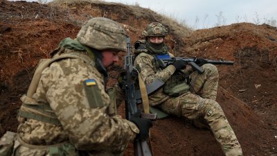 2月23日在顿涅茨克地区前线附近，乌克兰军人在举行的军事训练演习中在战壕里就位。（图取自法新社）