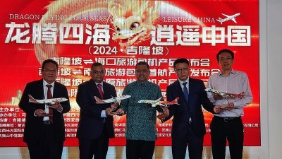 嘉宾们手持模型客机，为“龙腾四海逍遥中国”大型航空旅游产品发表会主持推介。左起为包一雄、南达斯、玛诺哈兰、吴德昀以及张杰鑫。