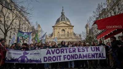群众在巴黎的法国参议院前举著横幅，上面写著“堕胎是由女性决定的基本权利”。（图取自法新社）
