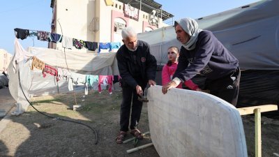 在加沙地带南部拉法，来自汗尤尼斯的巴勒斯坦人阿布在他的帐篷外搭建一张临时桌子。因为以军空袭，他的家园成了废墟，同时也失去了亲人。（图取自路透社）
