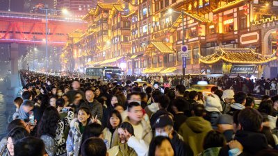 中国元旦有3天假期，民众趁机出游。周日倒数的晚上，重庆市洪崖洞游客如织 。（图取自中新社）