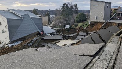 日本中部石川县周一发生里特制7.6级强震，位于震中轮岛市的房屋倒塌，路面也被震裂。（图取自共同社/路透社）