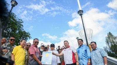 马来西亚记录大全代表埃德温（右3）在砂总理阿邦佐哈里（中）等嘉宾见证下，将“砂拉越祖国旗杆”被纳入马来西亚记录大全的证书移交给砂拉越州务秘书拿督斯里莫哈末阿布峇卡玛祖吉。