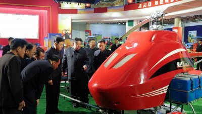 朝鲜官媒周三发布的照片显示，最高领导人金正恩周二参观农业机械展览时看著一架无人驾驶直升机。（图取自朝中社/路透社）