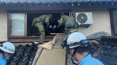 日本防卫省（部）联合参谋部周二发布的照片显示，在日本石川县轮岛市一所被震塌的民宅中，日本自卫队士兵展开救援行动。（图取自日本防卫省联合参谋部/路透社）