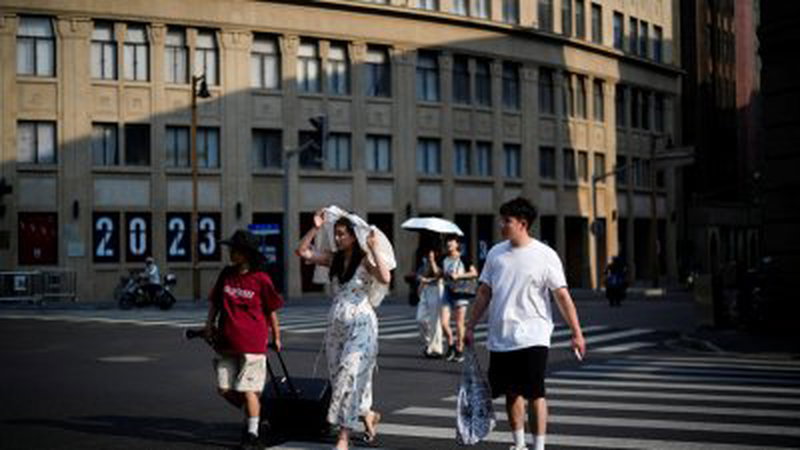 中国上海市去年8月遭遇热浪，民众穿清凉装出门，并撑伞、戴帽甚至用衣物遮阳。（路透社档案照）