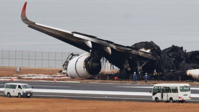 日本航空一架空巴A350-900型飞机，周二与DHC-8型飞机相撞起火，烧毁的飞机残骸周三仍在羽田机场的跑道上。（取自路透社）