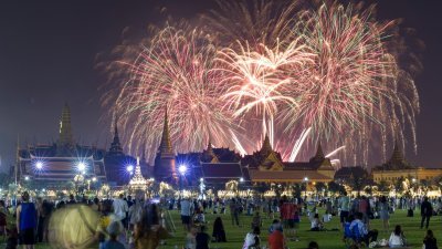 泰国曼谷元旦庆祝活动期间，烟火在大皇宫上空绽放，现场挤满了观赏烟花的当地人和外国游客。（图取自路透社）