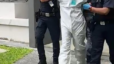 涉案男子身穿防护衣遭警方带走。