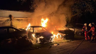 2辆停在修车厂外的废弃车无故著火，消拯员耗时10分钟成功控制火势。（图由消拯局提供）