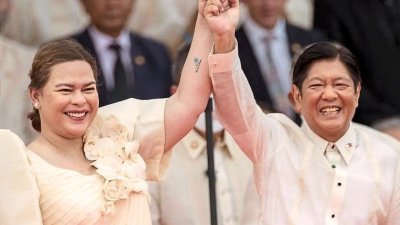2022年6月在马尼拉举行的就职典礼上，小马科斯和杜特蒂女儿莎拉高举互握的手，两人分别宣誓为菲律宾总统和副总统。（图取自路透社档案照）