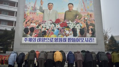 1月1日元旦当天，朝鲜平壤的民众在已故最高领导人金日成和金正日的马赛克肖像前鞠躬表达敬意。（图取自法新社）