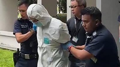 警方逮捕穿上防护服的郭英福，以保护留在他身上的证据。（档案照）