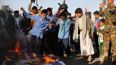 也门爆发大规模抗议活动，“青年运动”的支持者聚集一起燃烧以色列和美国国旗，谴责美英两军对也门的空袭。（图取自路透社）