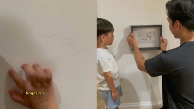 阿菲克将儿子在墙上的涂鸦当“画作”框起来。
