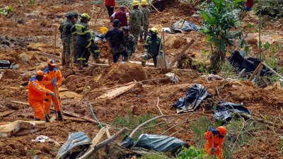 哥伦比亚西北部周五下午因暴雨引发山体滑坡，大批消防员、士兵和居民在搜索有无人被埋。（图取自法新社）