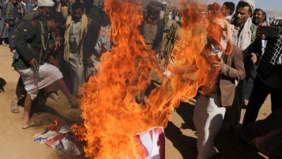 在也门首都萨那附近，“青年运动”的支持者焚烧美国和英国的国旗抗议。（图取自路透社）