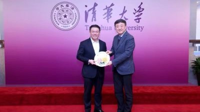 北京清华大学副校长杨斌教授（右）赠送纪念品予倪可敏。