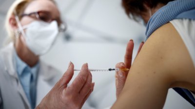 2021年12月17日，一名护士在法国一个疫苗接种中心，为一名医护人员接种新冠疫苗。（图取自路透社）