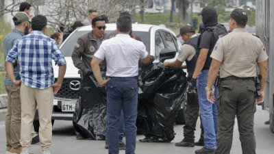 厄瓜多尔检察官瓦瑞兹遭到枪杀后，到场处理的国家警察成员搬运其遗体。（图取自法新社）