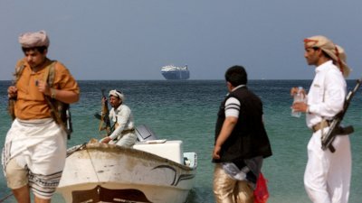 图为上月5日，在也门萨利夫海岸附近，也门“青年运动”武装人员站在被扣押的“银河领袖”号商船的海滩上。（路透社档案照）