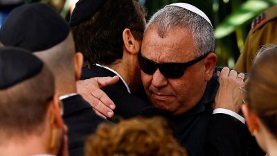 以色列战争内阁部长艾森科特去年12月8日在海尔兹利亚市，为在加沙北部战场上阵亡的儿子盖尔举行葬礼，到场的以色列总统赫尔佐格拥抱艾森科特表达慰问。（路透社档案照）