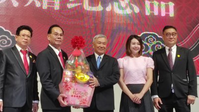 陈金福（左2）在金健城（左起）、廖彩彤和锺谦明陪同下颁赠礼篮给黄锋（左3）