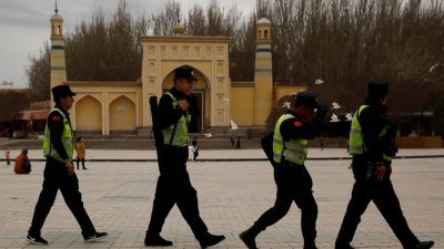 2017年3月22日在中国新疆维吾尔自治区喀什老城，警察在艾提尕尔清真寺前巡逻。（图取自路透社档案照）