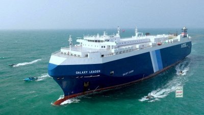 2023年11月20日，日本运营的货船“Galaxy Leader ”号在“青年运动”船只围绕之下，在红海航行。（图取自“青年运动”媒体/路透社档案照）