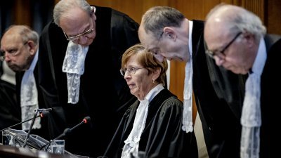 国际法院院长多诺霍（中）和国际法院法官们当地时间周五，在南非控告以色列的种族灭绝案在海牙宣布判决之前抵达国际法院。（图取自法新社）