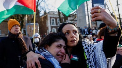 亲巴勒斯坦的活动人士在荷兰海牙国际法院外对裁决喜极而泣。（图取自路透社）