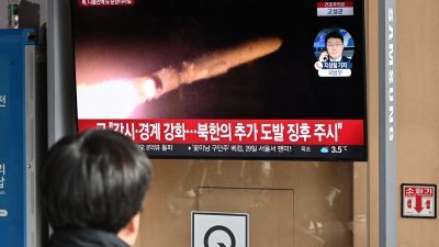 朝鲜周日从东部海域发射数枚巡航导弹，首尔火车站一名男子关注电视荧幕播报的相关新闻。（图取自法新社）