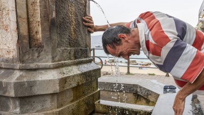 意大利西西里2021年8月11日出现破纪录高温，难忍炎热天气的民众，用公共水池的水浇头降温。（图取自法新社）