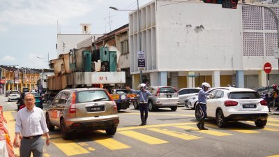 拖格罗里高度超标缘故而被“卡”在八爪鱼天桥底下，引发交通阻塞，槟岛市政厅交通纠察员立即赶赴现场进行协调。 