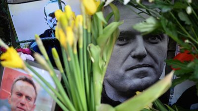 在德国法兰克福的临时悼念处，人们在纳瓦尔尼的肖像周围摆放鲜花致哀。（图取自法新社）