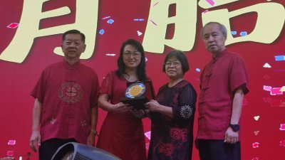 郑敏莉（左2）颁发纪念品予退休校长唐月胎，左起为韩斌元及郑国华。