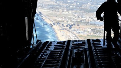 美国空军装卸员周六准备向加沙上空空投装有食品和水的人道主义援助包裹。（图取自美国国防部/法新社）